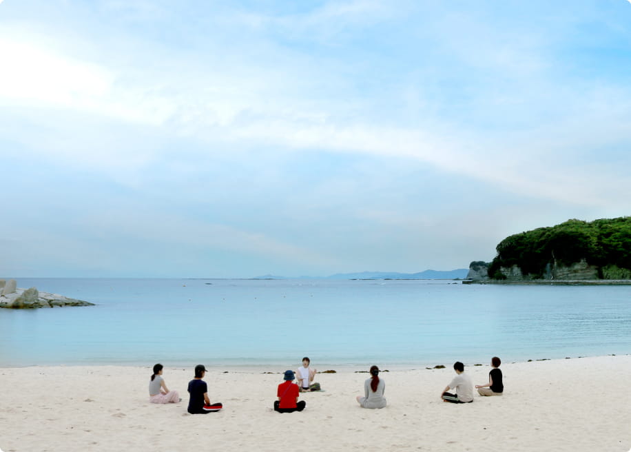 白浜の海を前に、それぞれの時間を過ごす参加者たち